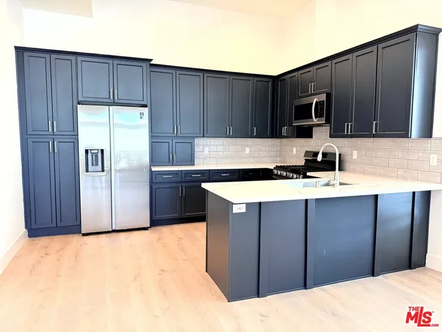 a kitchen with stainless steel appliances granite countertop a refrigerator and a sink
