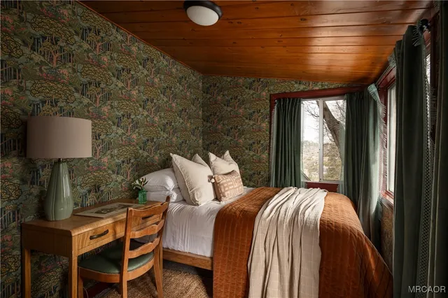 a bed sitting in a bedroom next to a window