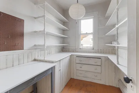 a kitchen with a window wooden cabinets and a sink