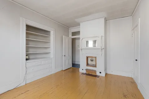 a view of an empty room with cabinet and a window
