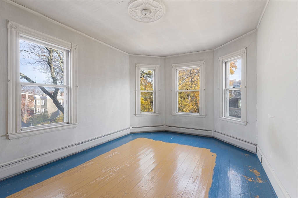 39 Ellery Street, Unit 6 Cambridge, MA 02138 - Photo 6 of 14 a view of an empty room with wooden floor and a window