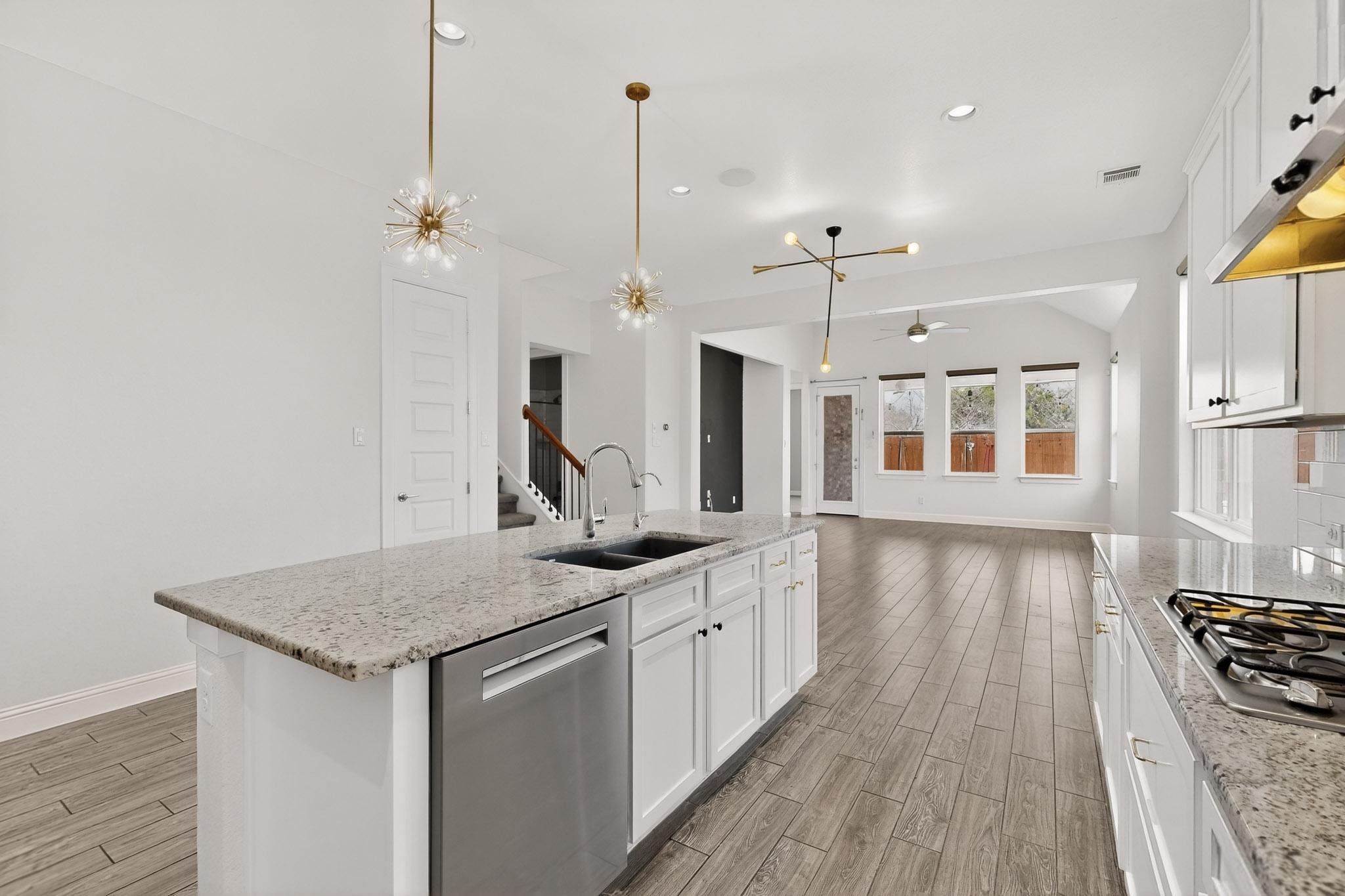 3137 Catalina Ranch Road Leander, TX 78641 - Photo 7 of 21 Kitchen featuring white cabinetry, stainless steel appliances, wood tiled floors, and light stone counters