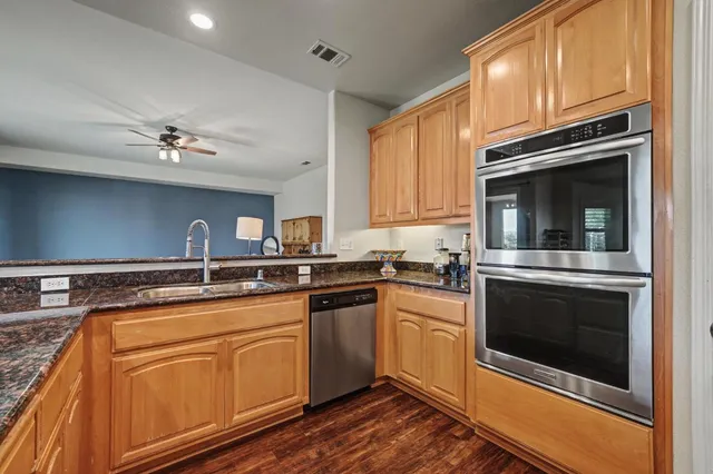 a kitchen with cabinets stainless steel appliances and a sink
