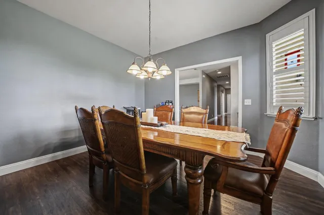 a dining room with furniture a chandelier and wooden floor