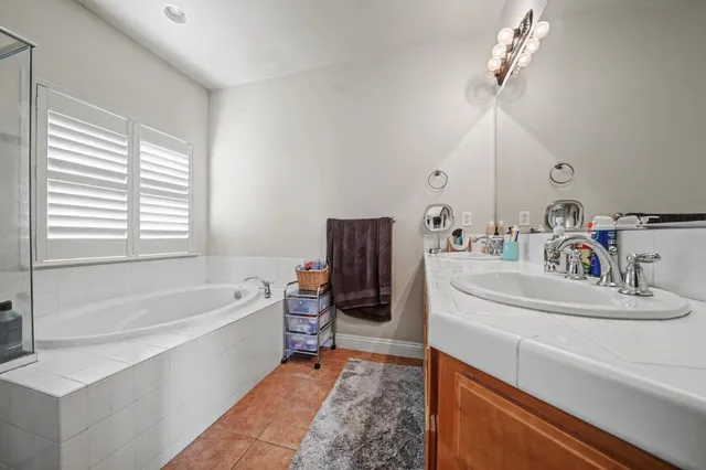 a bathroom with a tub sink and mirror