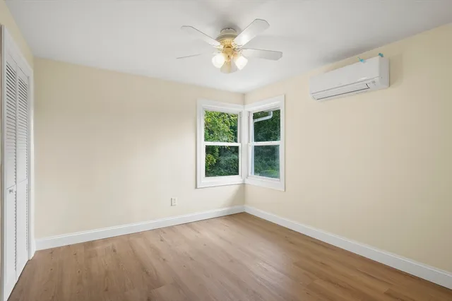 an empty room with wooden floor and window