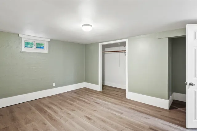 an empty room with wooden floor and closet