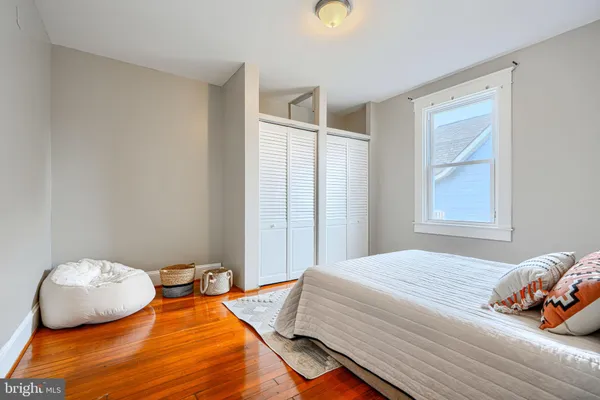 a view of a bedroom with wooden floor and a bathroom