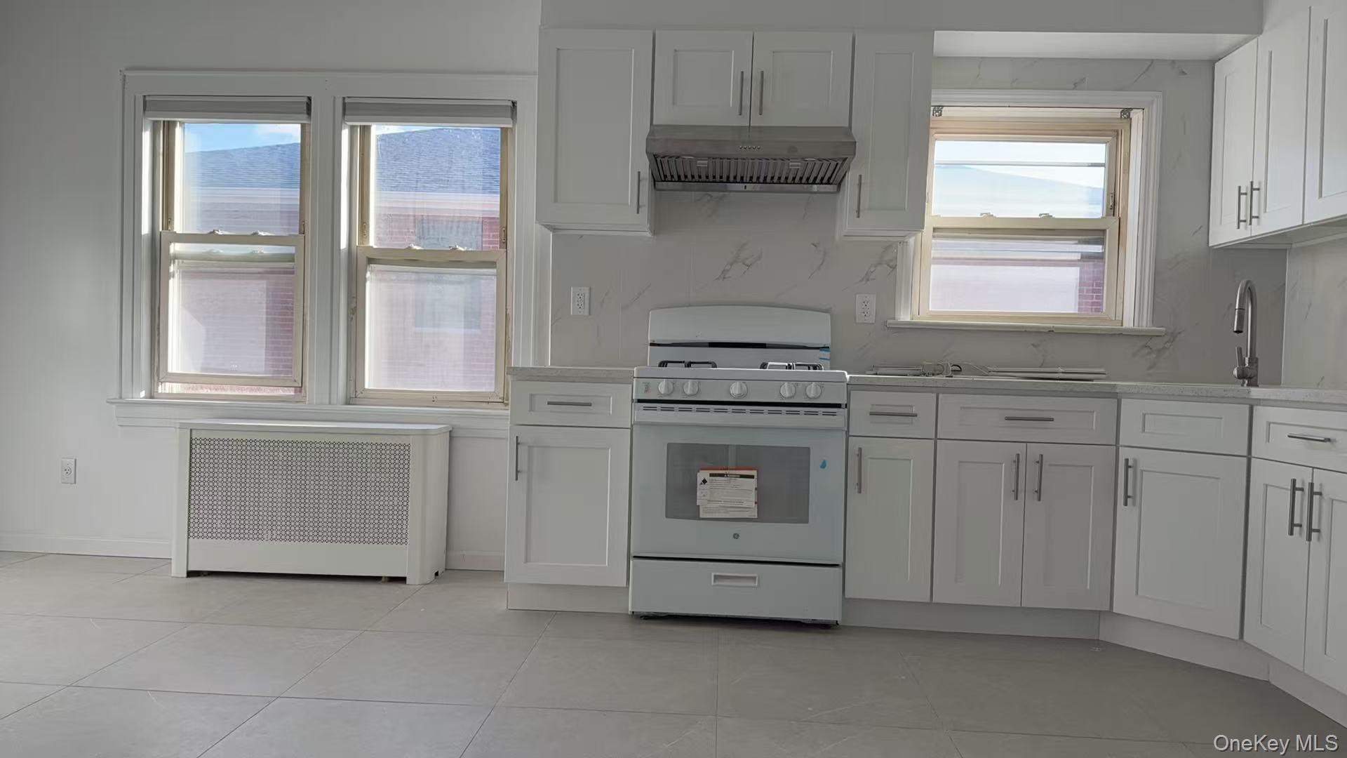 40-14 190th Street, Unit 2 Queens, NY 11358 - Photo 1 of 6 a kitchen with cabinets appliances and a window