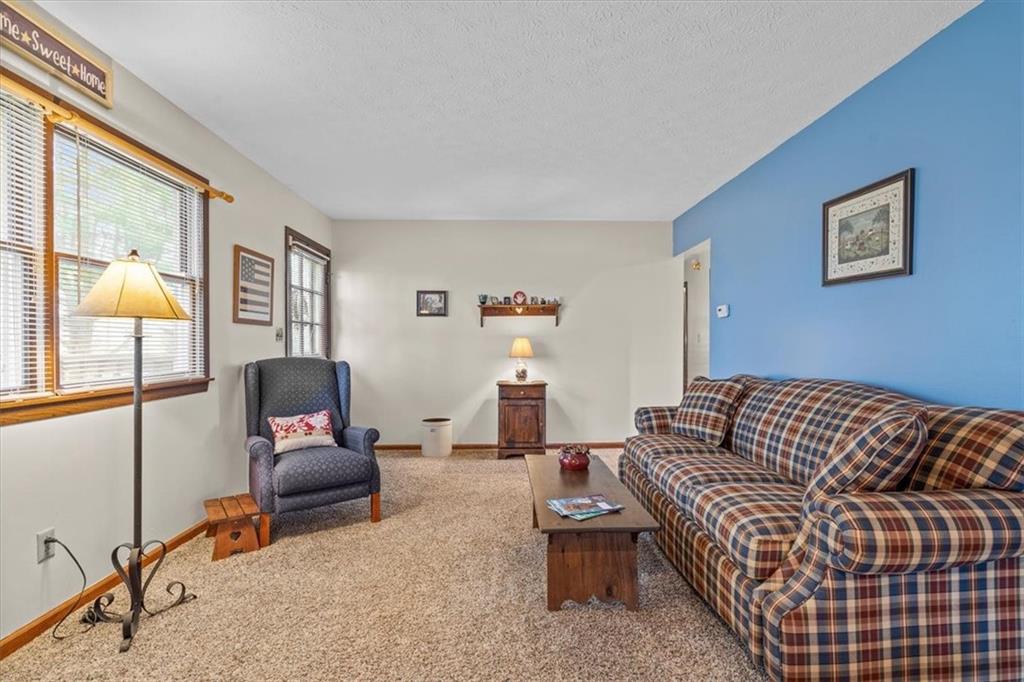173 Amsterdam Road Grove City, PA 16127 - Photo 4 of 25 a living room with furniture a lamp and a window