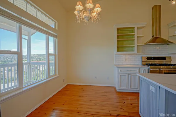 a kitchen with a window wooden floor and a stainless steel appliances