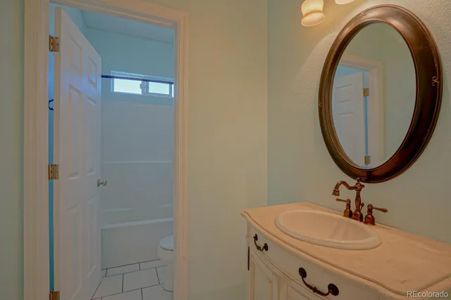 a bathroom with a sink a toilet and a mirror