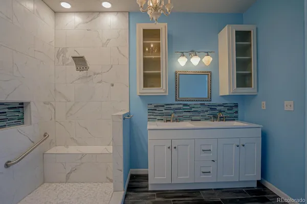 a bathroom with a granite countertop sink a toilet and mirror