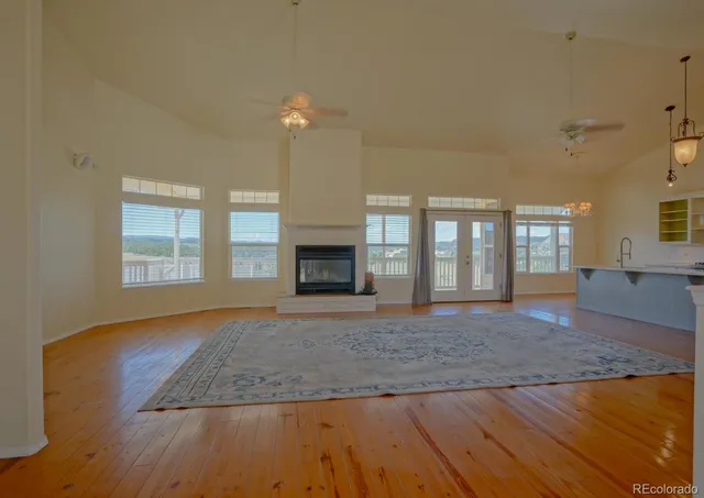 a view of an empty room with window and wooden floor