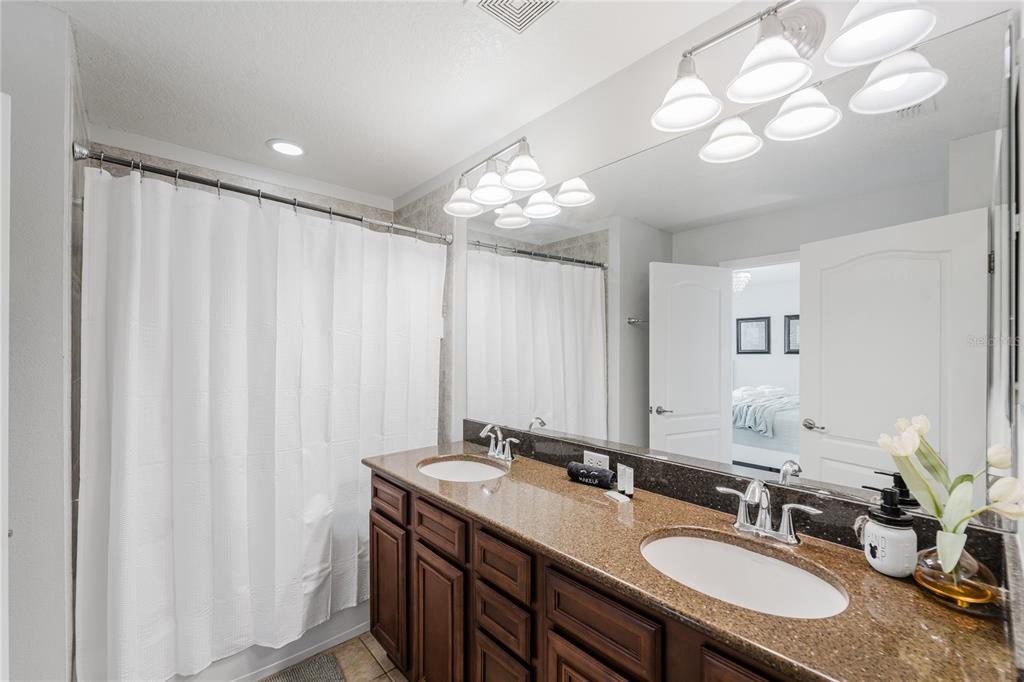 8961 Majesty Palm Road Kissimmee, FL 34747 - Photo 23 of 40 a bathroom with a double vanity sink and a mirror