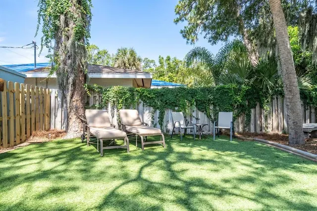 a view of a backyard of a house with a large tree
