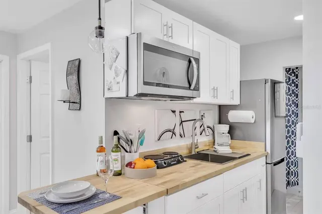 a view of a patio with table and chairs potted plants and large tree
