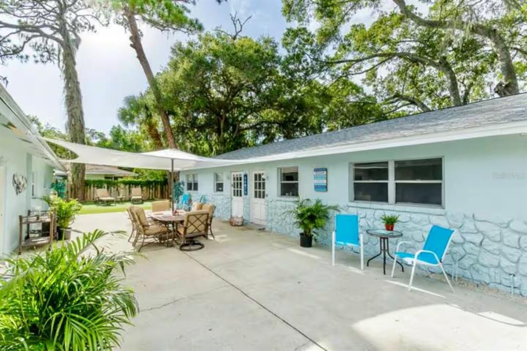1317 13th Street, Unit B Sarasota, FL 34236 - Photo 24 of 36 a view of a patio with table and chairs potted plants and large tree