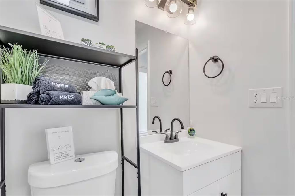 1317 13th Street, Unit B Sarasota, FL 34236 - Photo 25 of 36 a bathroom with a toilet sink and mirror