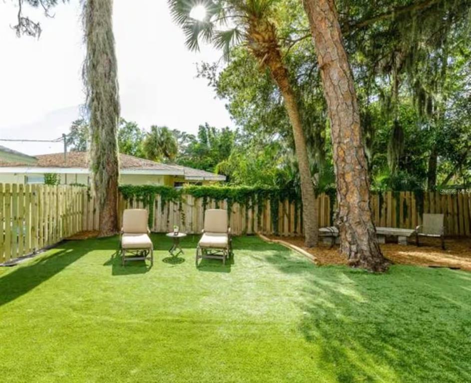1317 13th Street, Unit B Sarasota, FL 34236 - Photo 32 of 36 a view of a backyard with table and chairs a fire pit and grass
