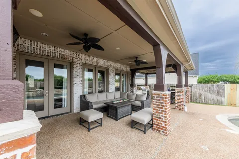 a outdoor space with patio the couches and a fireplace with the potted plants