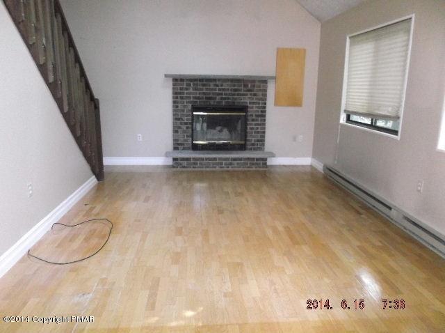 935 Decker Road Bushkill, PA 18324 - Photo 4 of 15 a view of a livingroom with wooden floor and a fireplace