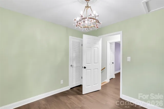 wooden floor in an empty room with a chandelier