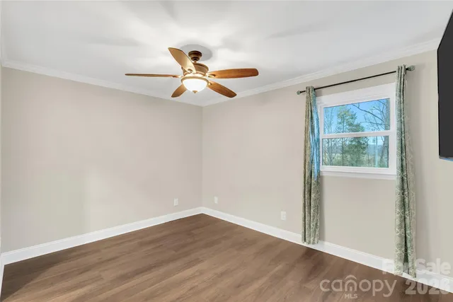 a view of a big room with wooden floor and windows