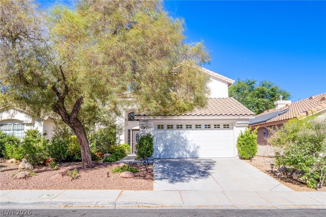 253 Camelback Ridge Avenue Henderson, NV 89012 - Photo 1 of 26 Mature trees and low-maintenance landscaping frame the exterior of this tile-roofed residence.