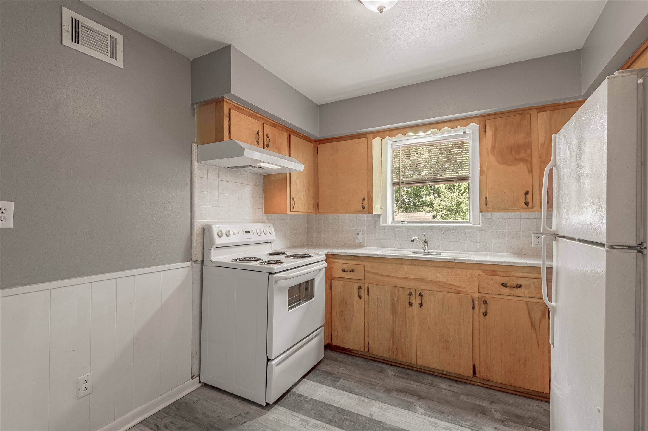 818 University Avenue, Unit 7 Huntsville, TX 77320 - Photo 12 of 25 a kitchen with a stove a sink and a refrigerator