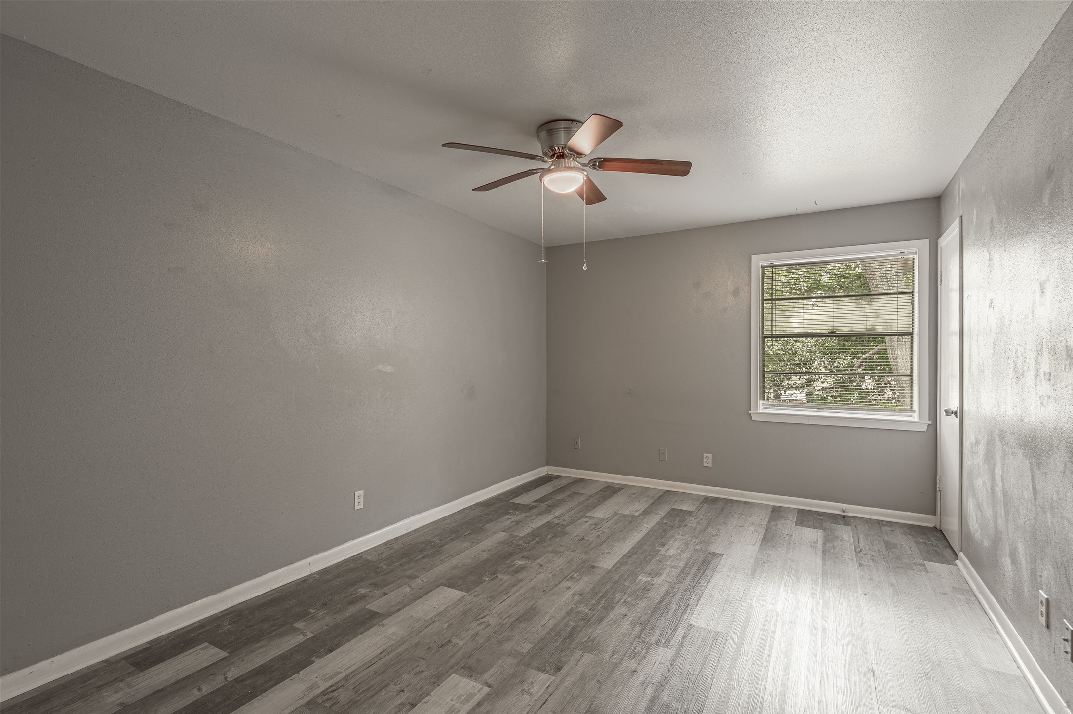 818 University Avenue, Unit 7 Huntsville, TX 77320 - Photo 15 of 25 an empty room with wooden floor ceiling fan and windows