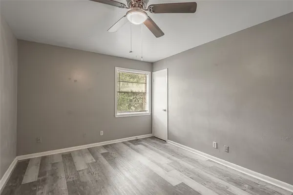 an empty room with a window and a fan