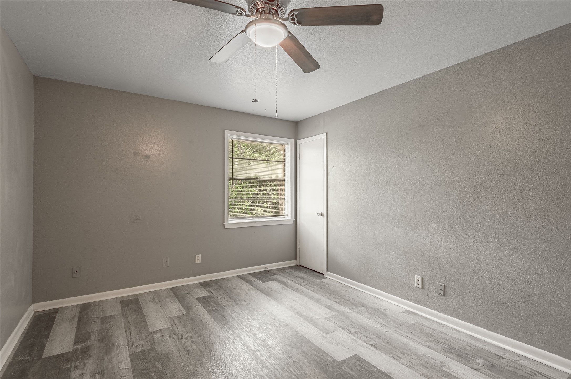 818 University Avenue, Unit 7 Huntsville, TX 77320 - Photo 16 of 25 an empty room with a window and a fan