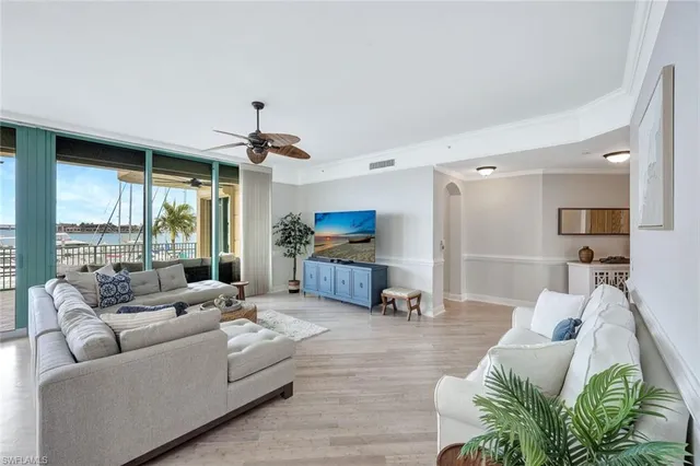 a living room with furniture ceiling fan and a large window