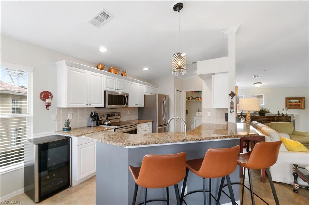 359 Dover Place, Unit E204 Naples, FL 34104 - Photo 14 of 49 a kitchen with stainless steel appliances kitchen island granite countertop a sink and cabinets