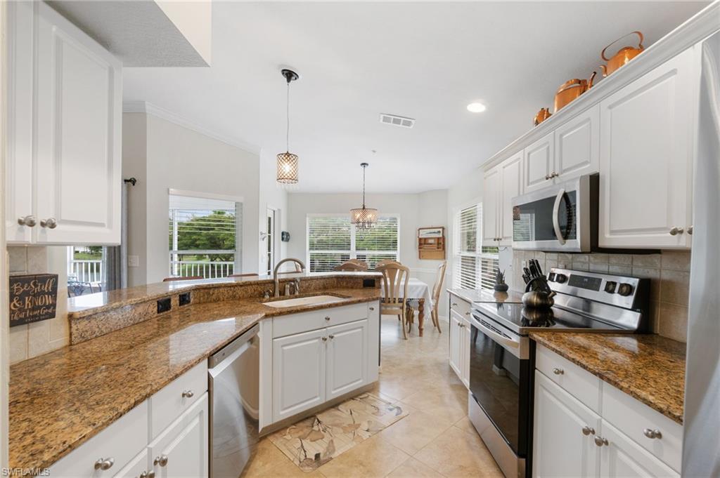 359 Dover Place, Unit E204 Naples, FL 34104 - Photo 16 of 49 a kitchen with stainless steel appliances granite countertop a sink a stove and cabinets