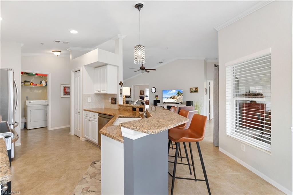 359 Dover Place, Unit E204 Naples, FL 34104 - Photo 17 of 49 a very nice looking dining room with kitchen island stainless steel appliances a table and chairs