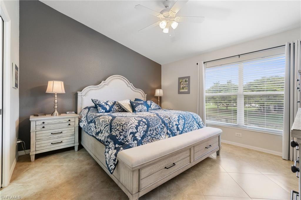 359 Dover Place, Unit E204 Naples, FL 34104 - Photo 21 of 49 a bed room with a bed and a chandelier