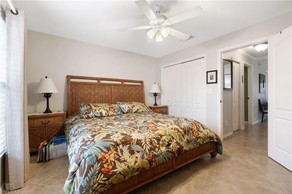 359 Dover Place, Unit E204 Naples, FL 34104 - Photo 26 of 49 a bedroom with a bed and a chandelier