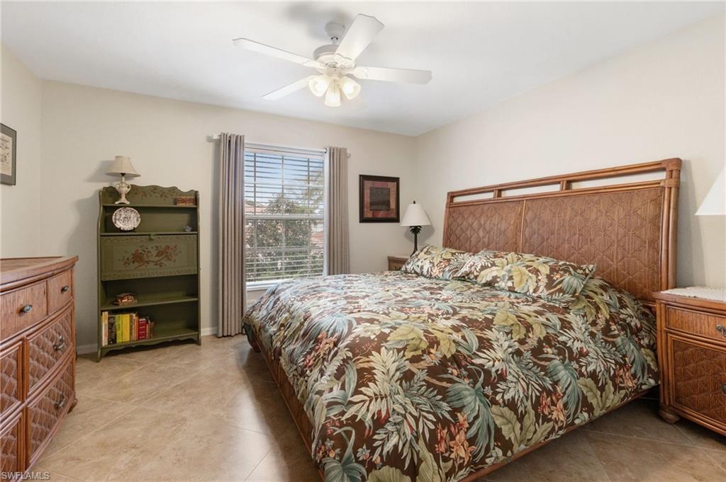 359 Dover Place, Unit E204 Naples, FL 34104 - Photo 28 of 49 a bedroom with a bed and a chandelier