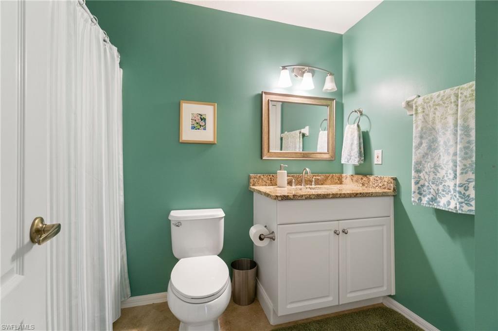359 Dover Place, Unit E204 Naples, FL 34104 - Photo 29 of 49 a bathroom with a toilet a sink and mirror