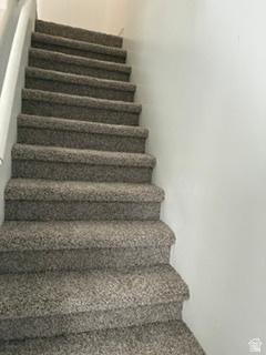 7936 Wycliffe Way Eagle Mountain, UT 84005 - Photo 22 of 37 Staircase featuring carpeting in a neutral tone and a white handrail