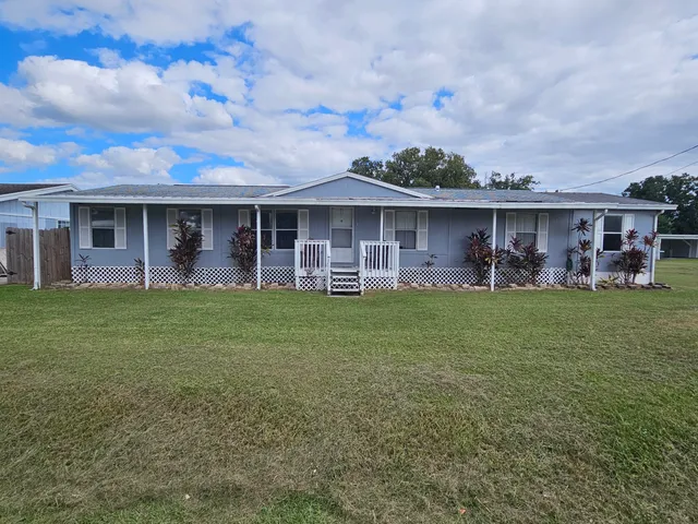 a front view of a house with a garden and plants