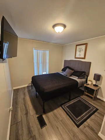 a bedroom with a bed and wooden floor