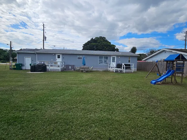 a view of a house with a yard and sitting area
