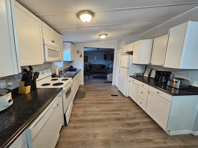 a large kitchen with stainless steel appliances granite countertop a stove and a sink
