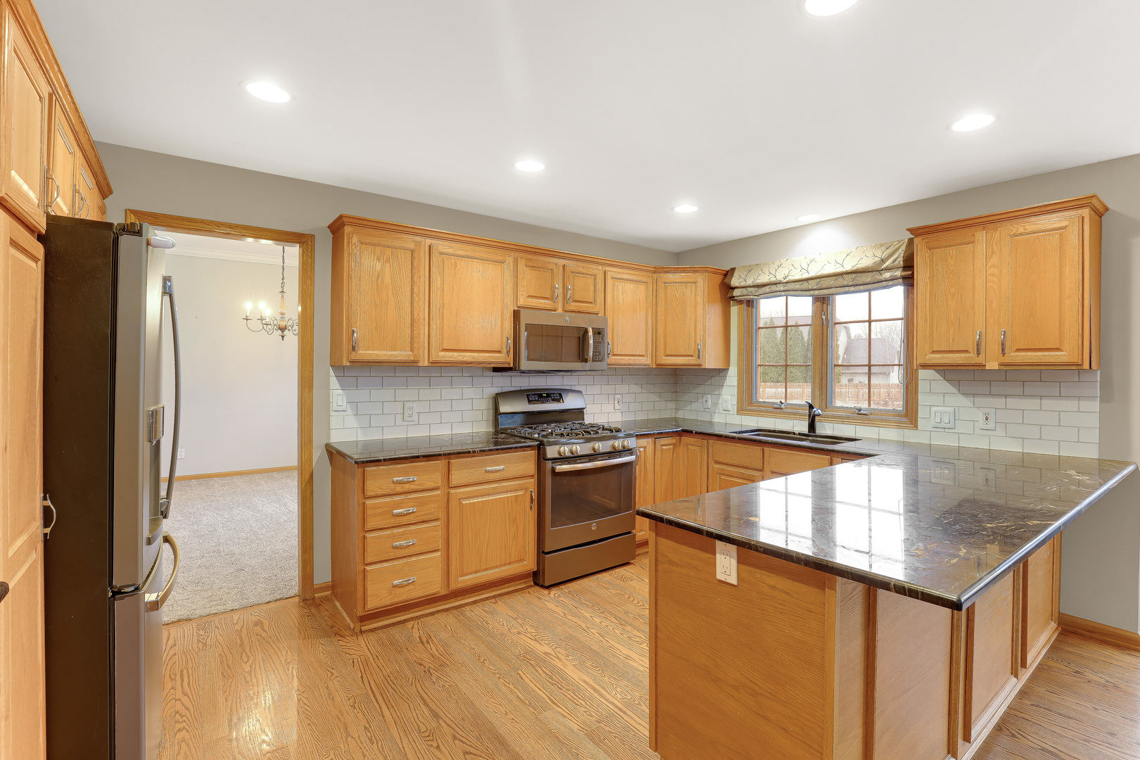 959 Willow Circle DeKalb, IL 60115 - Photo 13 of 39 a kitchen with stainless steel appliances granite countertop a refrigerator a sink dishwasher a stove and white countertops with wooden floor