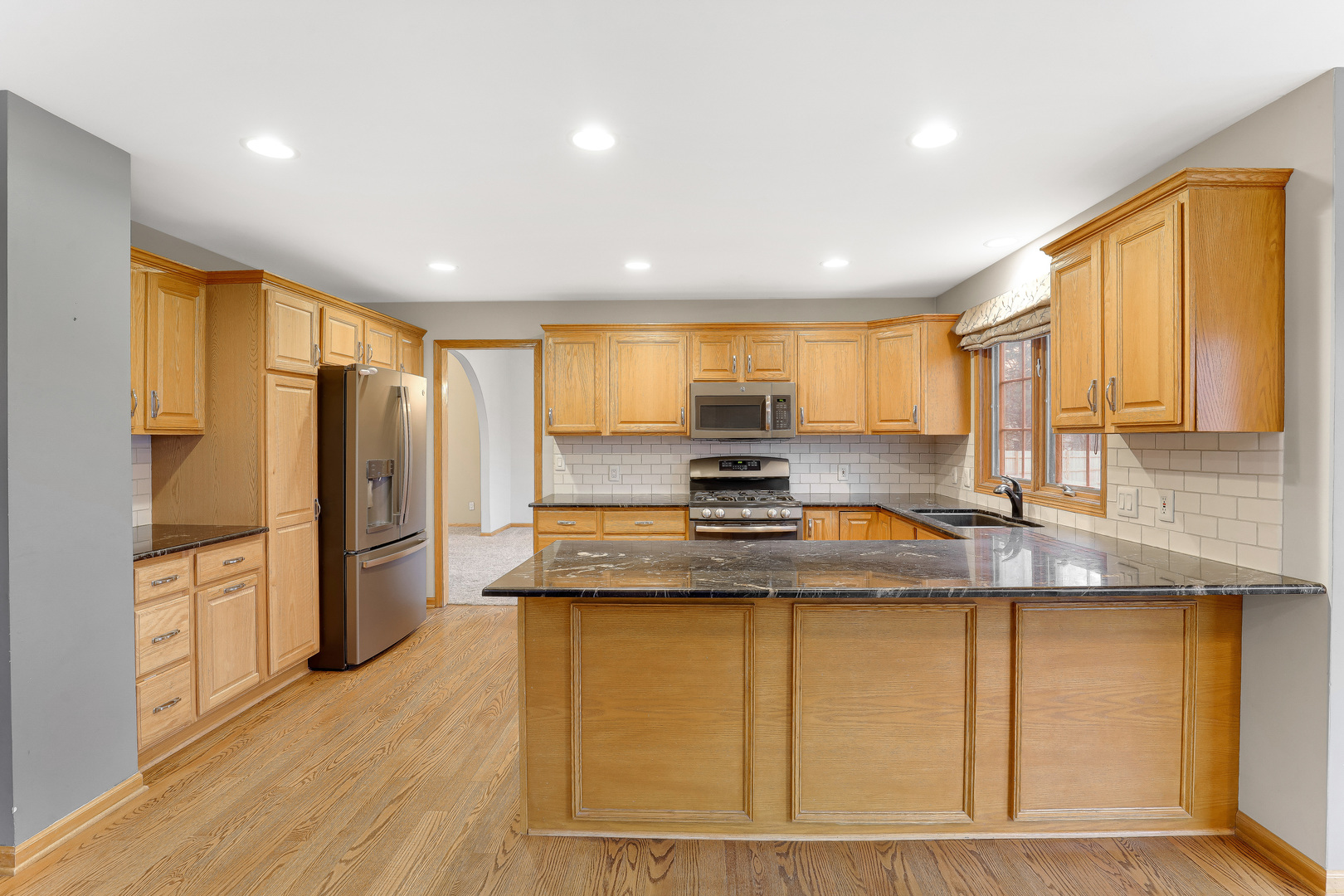 959 Willow Circle DeKalb, IL 60115 - Photo 16 of 39 a kitchen with stainless steel appliances granite countertop a refrigerator a stove and a sink with wooden floor
