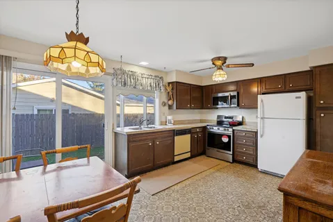 a kitchen with stainless steel appliances kitchen island granite countertop a refrigerator a stove and a sink with large countertops