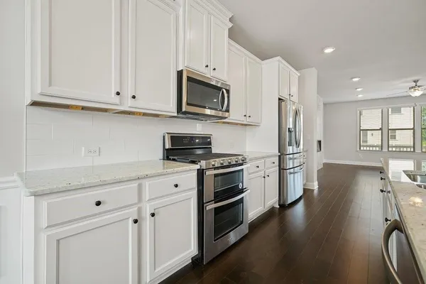 a kitchen with stainless steel appliances granite countertop a stove a sink and a refrigerator